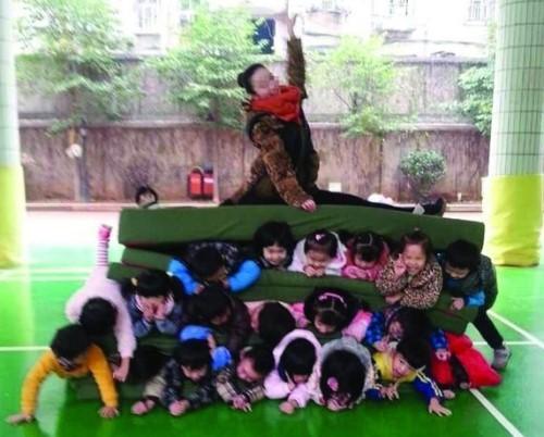 아이 18명 위에 女교사가 앉아… ‘인간 햄버거’ 논란