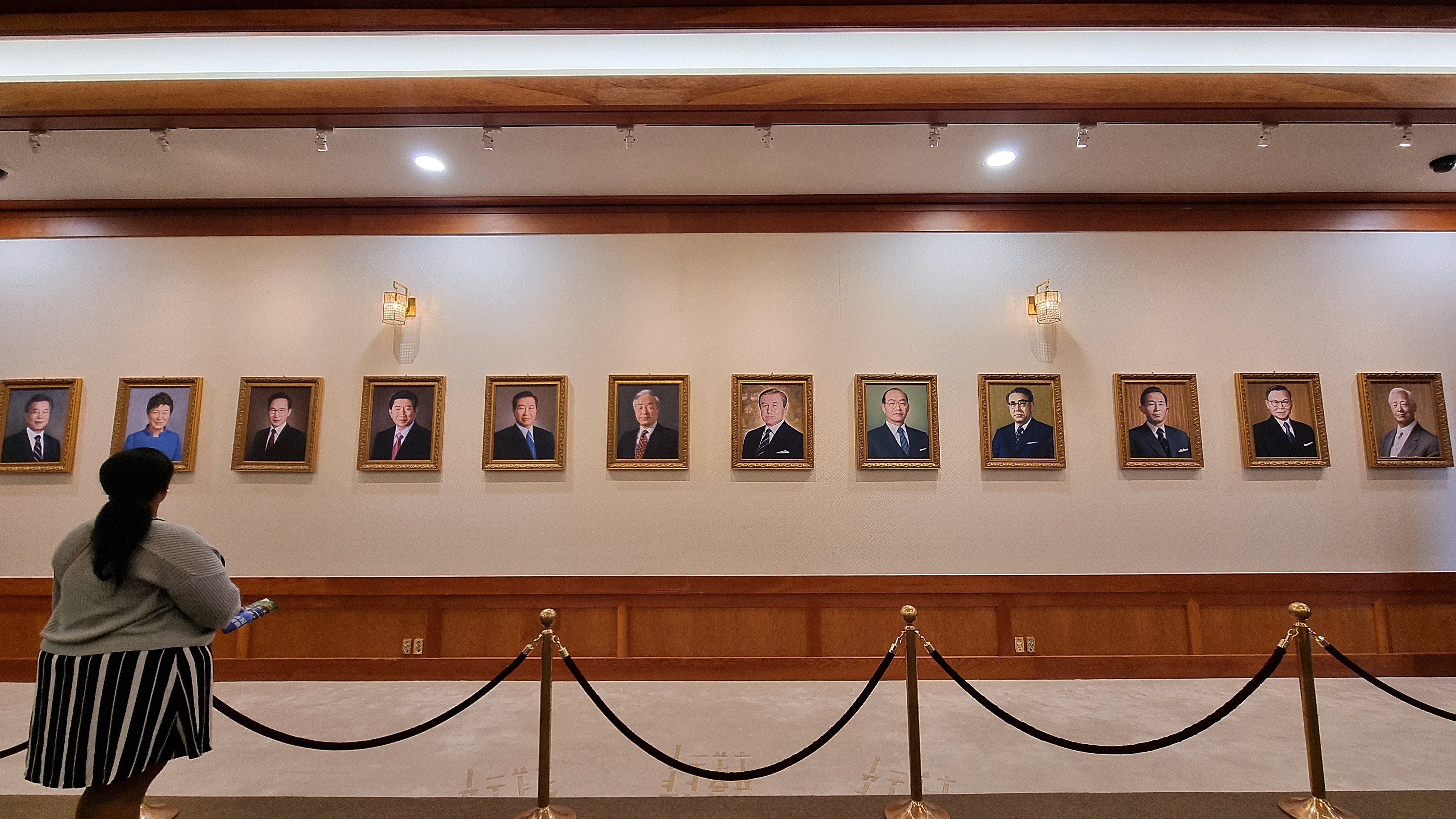 한 관람객이 본관에 걸려 있는 역대 대통령 12명의 초상화를 바라보고 있다.