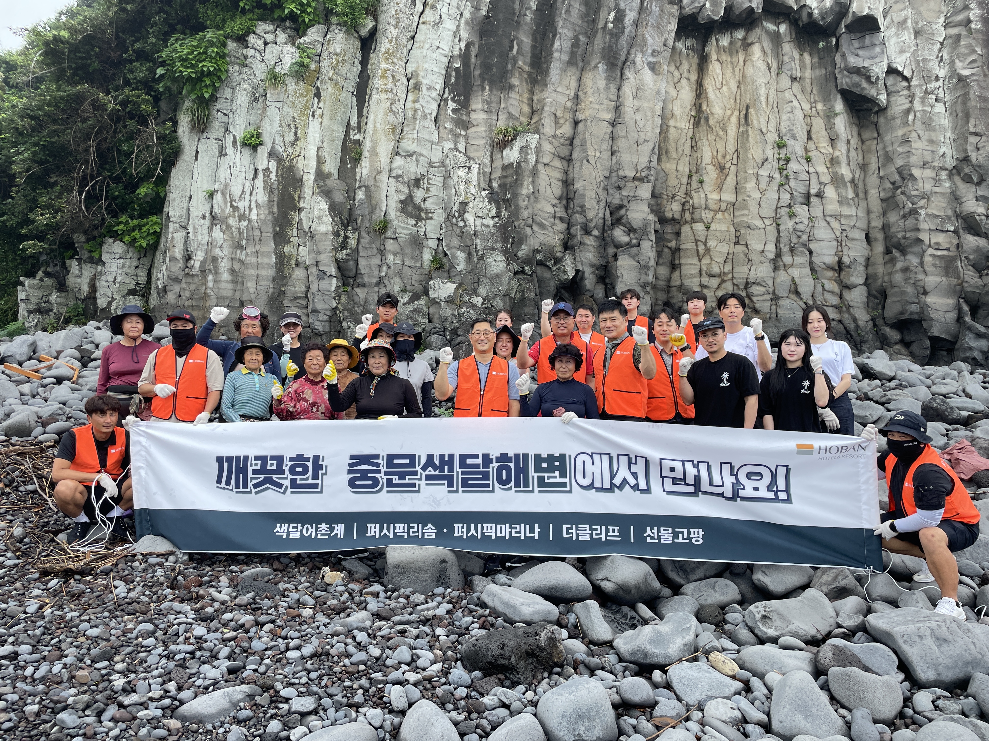 퍼시픽리솜 임직원과 색달어촌계 해녀들이 5일 제주 중문 색달해수욕장에서 환경정화 활동을 벌인 뒤 함께 기념촬영을 하고 있다. 사진: 호반호텔앤리조트 제공.