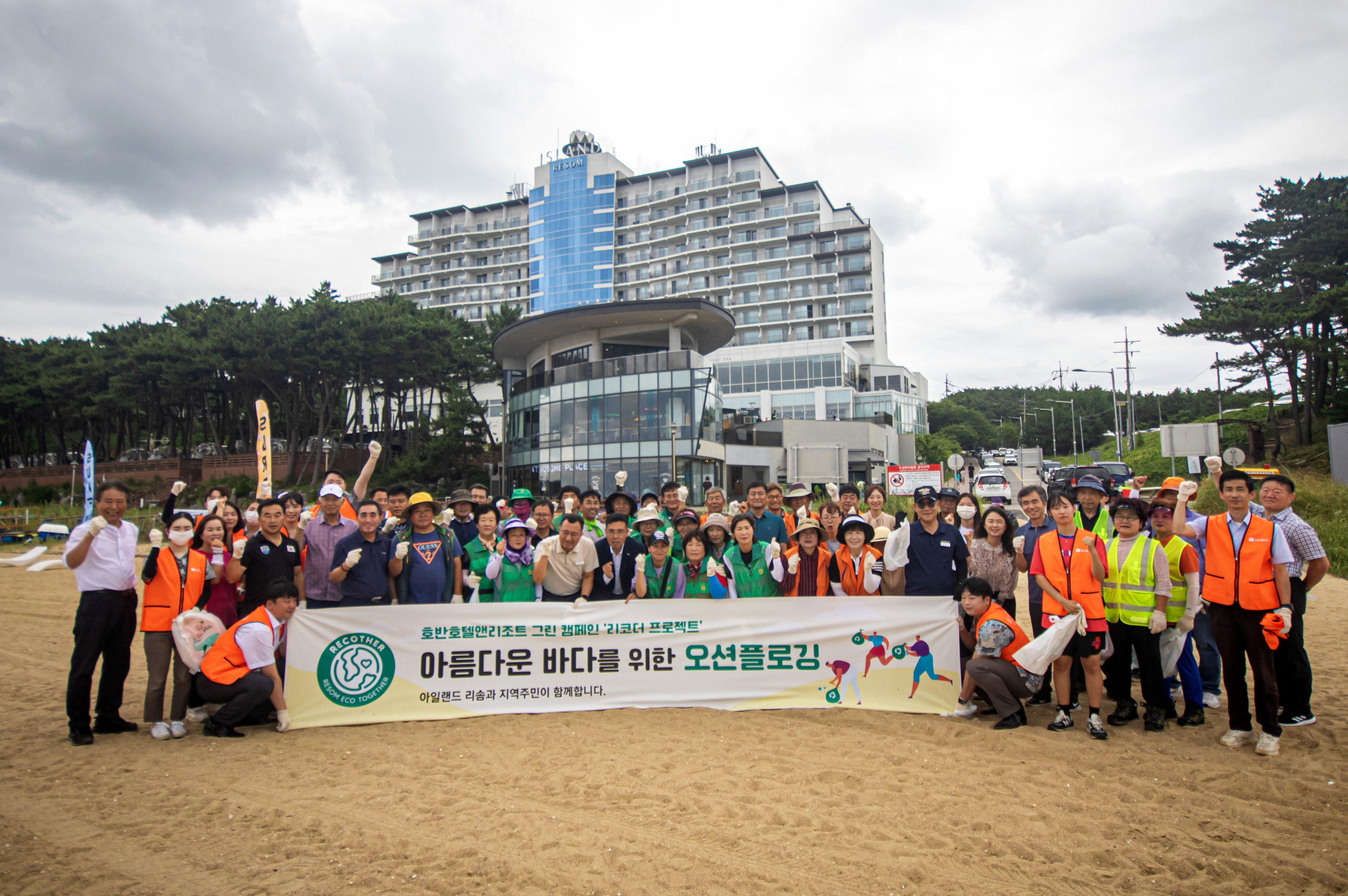 15일 충남 태안군 안면읍 꽃지해변에서 아일랜드 리솜 직원과 지역 주민들이  ‘비치플로깅’ 활동을 마친 뒤 기념촬영을 하고 있다.  사진 : 호반호텔앤리조트 제공.