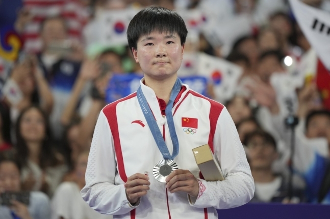 배드민턴 여자 단식 결승전에서 한국의 안세영에게 패한 허빙자오(27·중국·9위)가 스페인 국기 배지를 쥐고 시상대에 올랐다 뉴시스