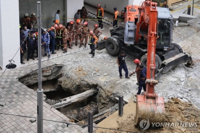 23일 오전 말레이시아 쿠알라룸푸르에서 발생한 싱크홀 현장. 싱크홀에 빠진 40대 여성 인도 관광객은 일주일 째 실종 상태다. 연합뉴스