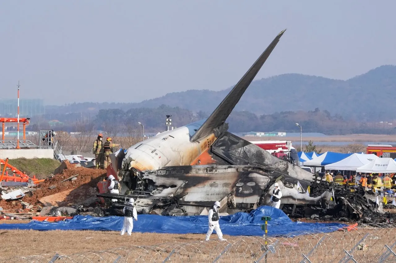 29일 오전 전남 무안국제공항에서 착륙하던 제주항공 여객기가 활주로를 이탈해 울타리 외벽과 충돌한 가운데 사고 현장에서 소방대원들이 인명구조를 하고 있다. / AP 연합뉴스