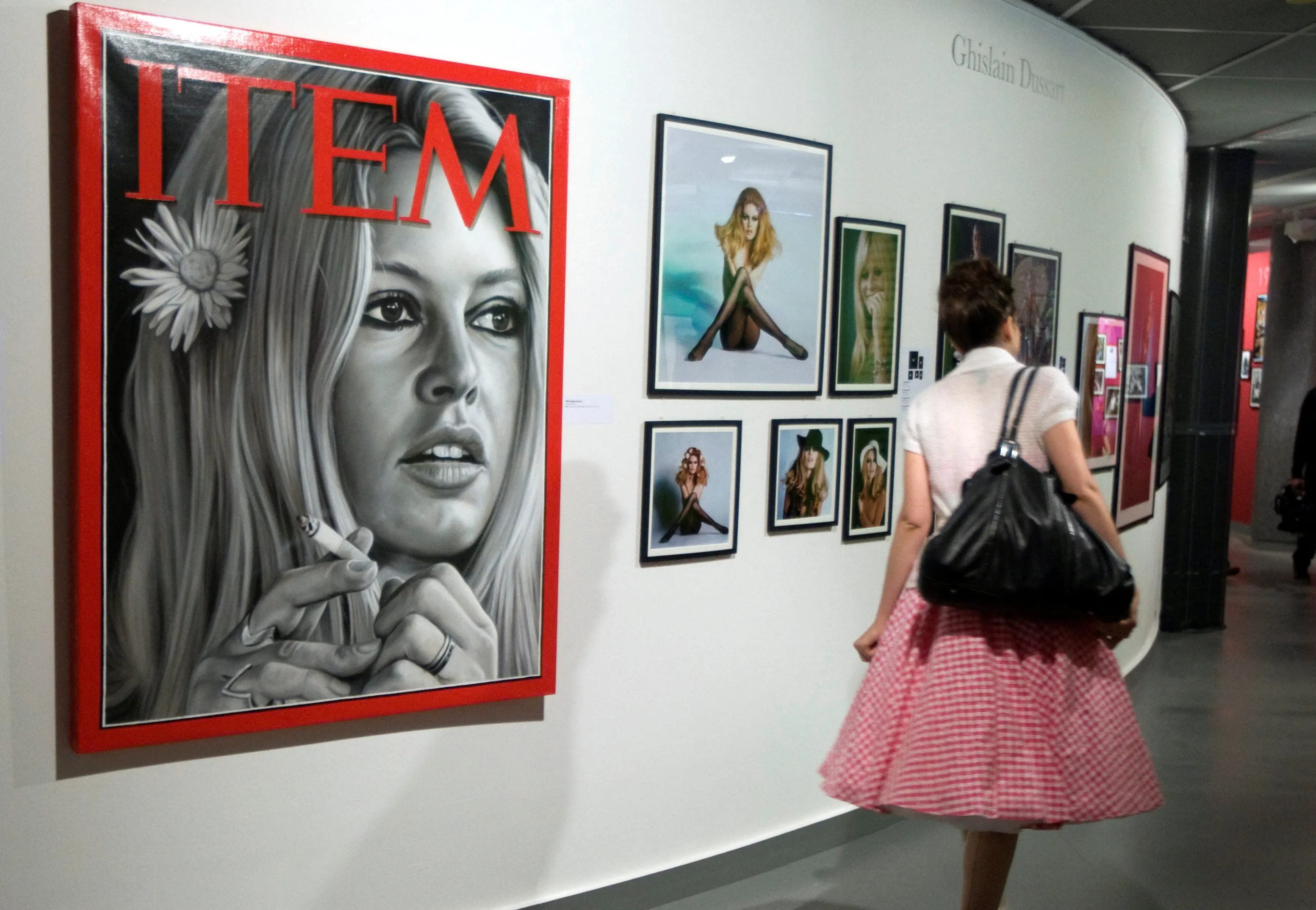 thumbnail - 2009년 9월 25일(현지시간) 프랑스 파리 서부 불로뉴-비양쿠르에서 열린 전시 미리보기 행사에서 한 여성이 배우 브리지트 바르도의 과거 사진이 전시된 공간 앞을 지나가고 있다. 로이터 연합뉴스