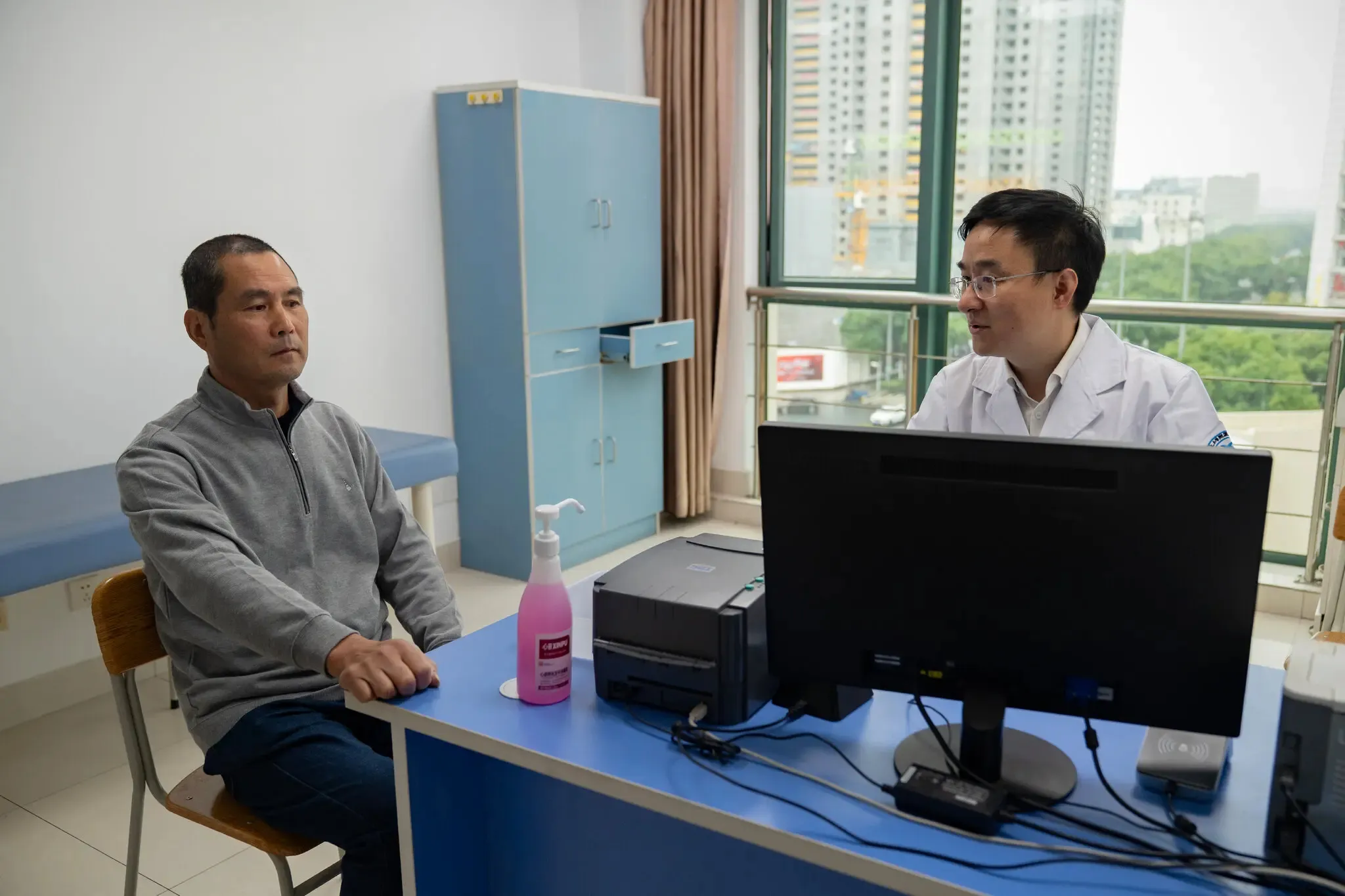 thumbnail - 중국 저장성 닝보의 닝보대 부속 인민병원에서 은퇴한 벽돌공 추이 스쥔(왼쪽)이 주커레이 췌장 전문의와 상담하고 있다. 인공지능(AI) 기반 진단 도구가 추이 씨의 췌장암을 초기 단계에서 발견하는 데 도움을 줬다. 뉴욕타임스