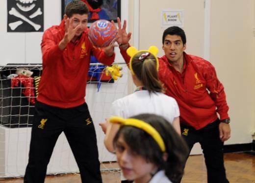 제라드와 한 여학생이 공 던지기 놀이를 하고 있는 중, ‘말썽꾸러기’ 수아레즈가 공을 가로채려 하고 있다.(리버풀 홈페이지)