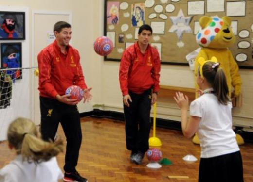 제라드와 한 여학생이 공 던지기 놀이를 하고 있는 중, ‘말썽꾸러기’ 수아레즈가 공을 가로채려 하고 있다.(리버풀 홈페이지)