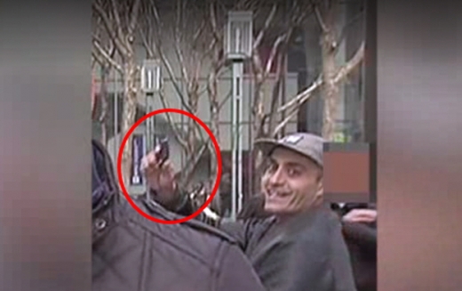 자신의 권총을 꺼내 보이는 남자를 확대한 모습.