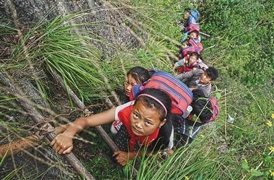 중국 쓰촨성 아투러얼촌 아이들이 학교를 가기 위해 깎아지른 듯한 절벽에 놓인 사다리를 타고서 내려가고 있다.