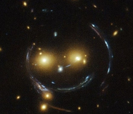 일명 ‘웃는 은하’로 공식적으로는 ‘SDSS J1038+4849’로 불리는 은하단이다. 두 눈은 은하들이며, 웃는 것처럼 보이는 선은 사실 강력한 중력 렌즈 효과로 빛이 굴절돼 보이는 것이다.