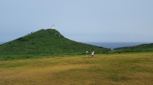 섭지코지의 해안 언덕, 멀리 태평양 한 가운데를 밝히던 등대가 눈에 들어온다. 4월 유채꽃이 필 즈음이면 섭지코지는 관광객들로 인해 발 디딜틈이 없을 정도로 아름다운 경치를 제공한다.