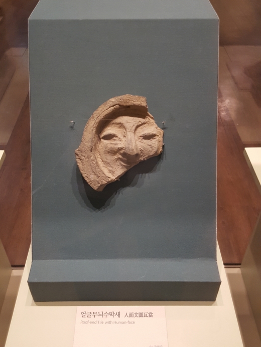 얼굴무늬수막새. 기왓골 끝에 사용되었던 것으로 보통의 암키와와 수키와에 비해 현존하는 수막새는 많지 않다. 흔히 모 대기업 로고를 떠올리는 관람객들이 많다.