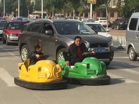 태연하게 신호를 지켜가며 차도 위에서 범퍼카를 운전하고 있는 중국의 두 남성. (사진=동방종합망)