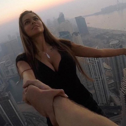 남성 조수의 한 팔에 의지한 채 몸을 뒤로 젖히고 있다.