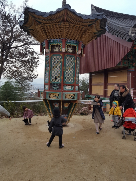 어린이들이 관촉사의 윤장대를 돌리며 즐거워 하고 있다. 팔각형의 윤장대를 한 번 돌리면 불경 한 권을 읽는다는 의미가 있다.