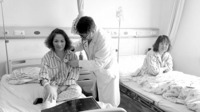 같은 부위에 같은 크기의 같은 종양이 생겨 같은 날 같은 의사에게 수술받은 장씨 자매가 수술을 마친 뒤 의사의 검진을 받고 있다. (사진= 선양바오)