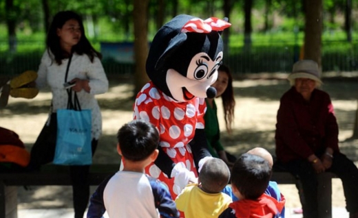 인 할머니가 미니 마우스 차림으로 아이들과 놀아주고 있다.(사진=환구시보 캡쳐)