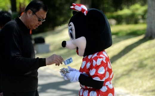 인 할머니는 아픈 며느리를 위해 미니마우스 인형 탈 뒤에 슬픔을 감춘 채 사진을 찍고 돈을 받는다. (사진=환구시보 캡쳐)(사진=환구시보 캡쳐)