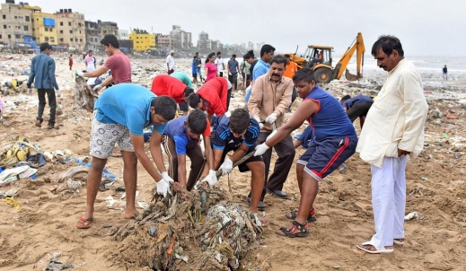 장갑을 낀 지역주민들이 삽을 이용해 모래에서 쓰레기 폐기물을 들어올리고 있다. (사진=힌두스타임즈)