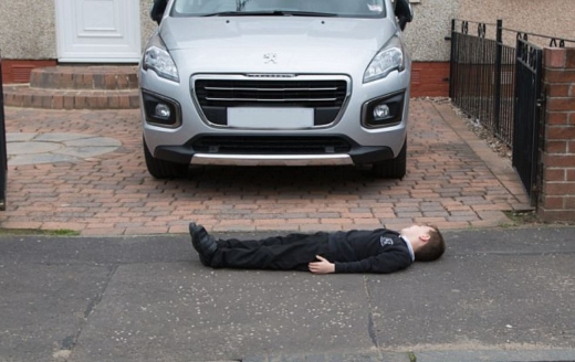 한 아이가 주차된 차 앞에 아무렇지 않게 누워있다. (사진=데일리메일 캡쳐)