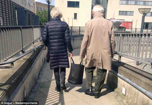 장 본 물건을 함께 나눠 들고 길을 걷는 노부부