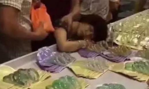 옥팔찌를 깨뜨린 여성이 매대에 그대로 쓰러져 실신해 있다. (사진=춘청완바오)