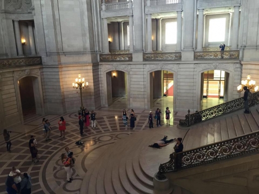 샌프란시스코 시청의 계단에 누워있는 스테파니를 신기해하며 사람들이 사진 촬영하고 있다. (사진=더썬)