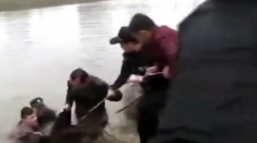 경찰이 시민들과 함께 강에 뛰어든 부자를 끌어올리고 있다.