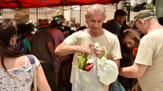 뜻하지 않은 선물을 받은 한 노인이 채소 봉지를 들고서 빙긋이 웃고 있다. (사진=암비토)