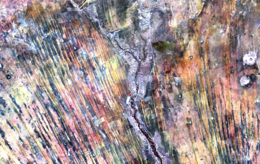 나미비아에 있는 칼라하리 사막 끝자락의 모습을 착색한 사진이다. 과거에는 비옥한 땅이었던 북부 지역에서 모래 언덕이 확산하고 있다. 중앙에 빨간색으로 표시된 부분은 건강한 초목들이 있는 곳이다. 이는 유일하게 남은 농장의 관개 시설이라고 NASA는 설명한다.