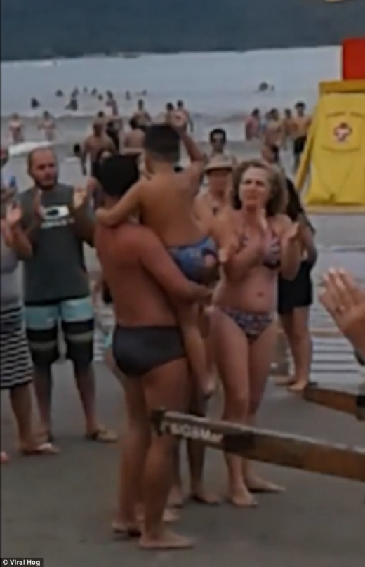 아이를 안고있는 남성에게 시선을 집중시키기 위해 주위에서 박수를 치고 있다.