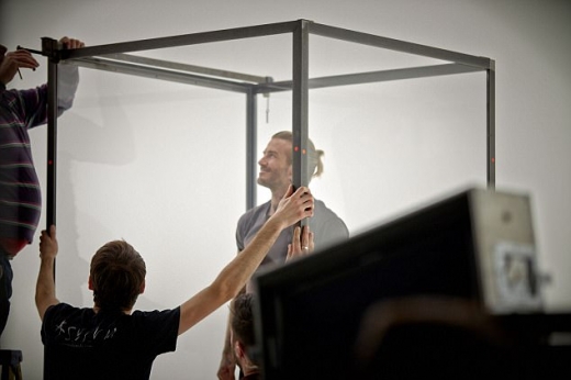 투명한 유리방으로 모기를 주입하는 스태프와 이를 바라보고 있는 데이비드 베컴