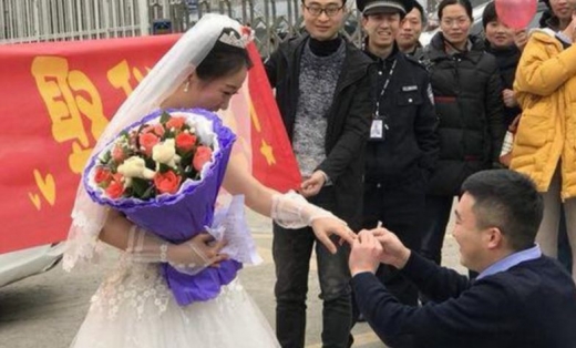 무릎을 꿇고 여자친구가 준비해온 반지를 손에 끼워주고 있다.