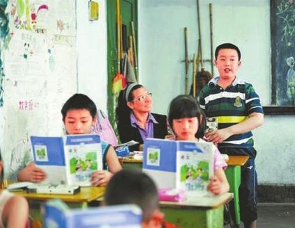 교실에 서서 발표 중인 바오, 그 옆에서 아들을 도와주고 있는 어머니 팽씨.