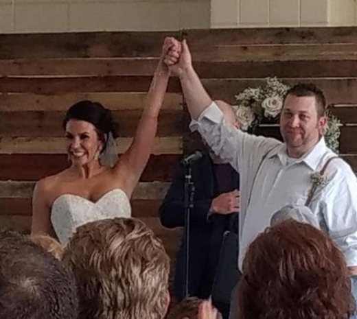 신랑신부가 피로연에서 하객들에게 손을 들어보이고 있다.