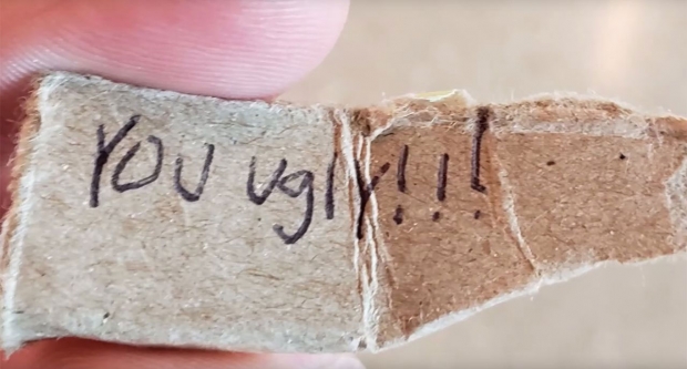 공항 직원이 닐 스트래스너에게 건넨 쪽지에는 “넌 못생겼어!”라고 쓰여 있다.(사진=닐 스트래스너/유튜브)