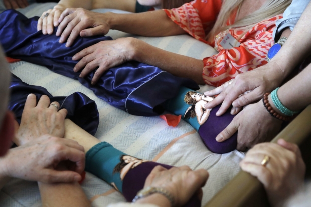 그가 숨을 거두자 옆에 앉아 있던 몇몇 사람은 그의 몸에 손을 얹으며 그의 마지막 가는 길을 배웅했다.