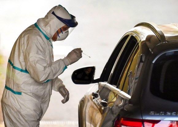 18일(현지시간)이탈리아 볼로냐의 현지 의료진이 차량 운전자에게 한국과 같은 ‘드라이브 스루’ 검사를 시행하는 모습.사진=AP 연합뉴스