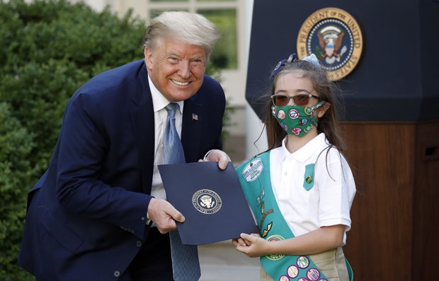 15일(현지시간) 백악관 로즈가든에서 열린 걸스카우트 관련 행사에서 마스크를 쓰지 않은 도널드 트럼프 미국 대통령이 마스크와 선글라스를 착용한 어린이와 포즈를 취하고 있다./사진=AP 연합뉴스