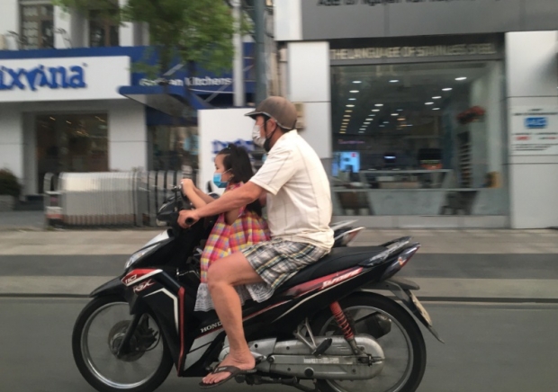 아빠와 함께 오토바이를 타고 호치민 시내를 질주하는 여아의 모습 
