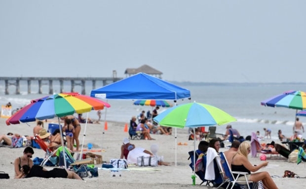 미국 플로리다 주정부가 신종 코로나바이러스 감염증(코로나19) 완화에 따라 코코아 비치 근처 스페이스 코스트 일대 해변 재개장에 나서자 26일(현지시간) 주민들이 해변에서 휴식을 취하고 있다.
