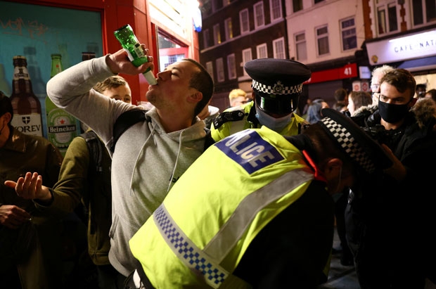 술집으로 몰려든 젊은이들은 거리두기는 물론 마스크 착용 지침도 무시한 채 마지막 축배를 들기 바빴다. 단속에 나선 경찰의 마스크 착용 지도도 소용없었다./사진=로이터 연합뉴스