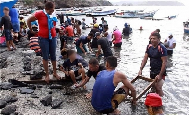 모래사장에서 보물을 찾고 있는 베네수엘라 해안 마을 주민들