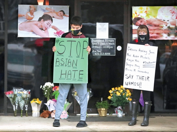 “아시아인 혐오범죄 멈춰라” - 3월 17일(현지시간) 미국 조지아주 애틀랜타의 ‘영 아시안 마사지’숍 앞에서 아시안·히스패닉 연대 단체 회원들이 “아시아인 혐오범죄를 멈춰라” 등이 적힌 피켓을 들고 있다. 전날 백인 남성 로버트 에런 롱이 스파숍 등 3곳에서 총기를 발사해 한국계 여성 4명 등 총 8명이 숨진 사건에 미국 사회 전체가 추모와 연대의 메시지를 내고 애도했다.애틀랜타 AP 연합뉴스