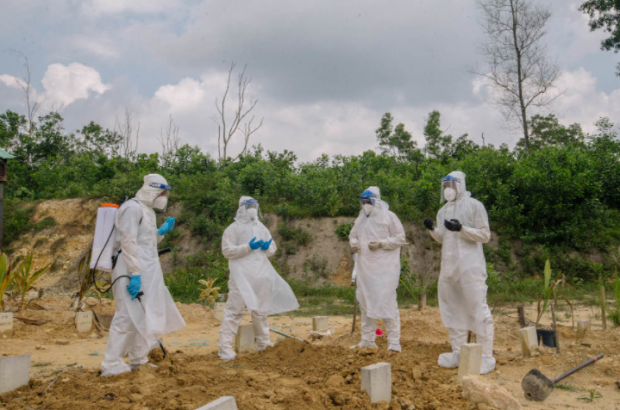 말레이시아에서 코로나19로 사망한 사망자의 시신을 매장한 뒤 소독작업을 하는 보건당국 관계자들
