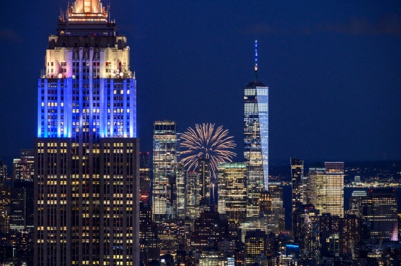 현지시간으로 지난 15일 밤, 뉴욕의 밤하늘을 수놓은 대규모 불꽃놀이. 방역해제를 선언한 뉴욕시가 코로나19 팬데믹을 극복한 시민들에게 축하와 감사의 뜻을 전하기 위해 마련된 행사다. 로이터 연합뉴스