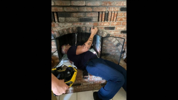 굴뚝 안에 몸이 낀 소녀를 살피는 소방관의 모습.