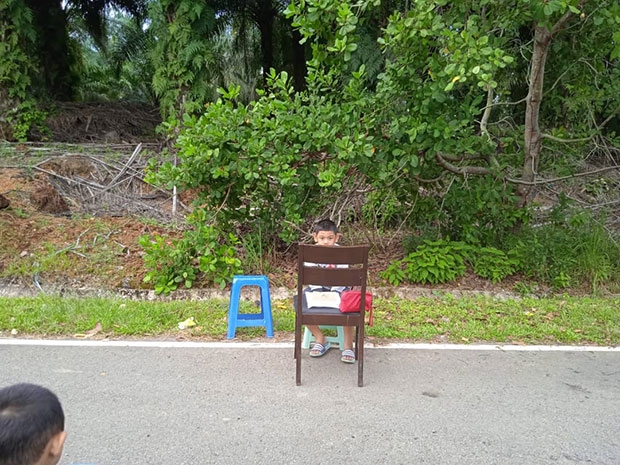 사진 속 어린이들은 책상 대신 끌고 나온 의자 위에 교과서를 펼치고 원격 수업에 집중한 모습이다.