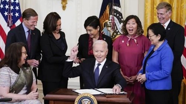 지난 5월 20일(현지시간) 미국 워싱턴DC 백악관 이스트룸에서 조 바이든 대통령(가운데)이 민주당 소속 상·하원 의원과 카멀라 해리스 부통령(왼쪽·3번째)이 지켜보는 가운데 아시아계 증오범죄 방지법안에 서명한 후 사용한 펜을 참석자에게 건네주고 있다./AP연합뉴스