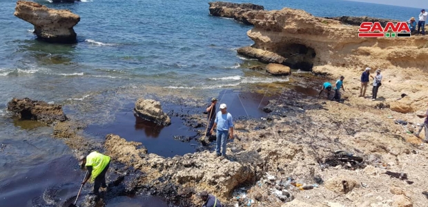 시리아 바니야스 해안에서 기름 제거 작업에 열중하는 주민들